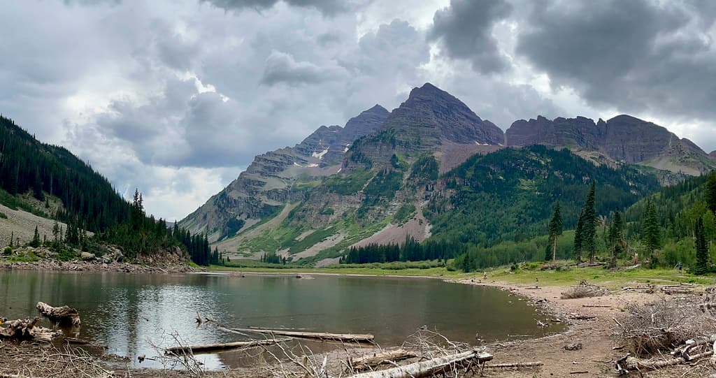 Looking back at Maroon and North Maroon from Crater Lake with storm clouds fully formed above them.