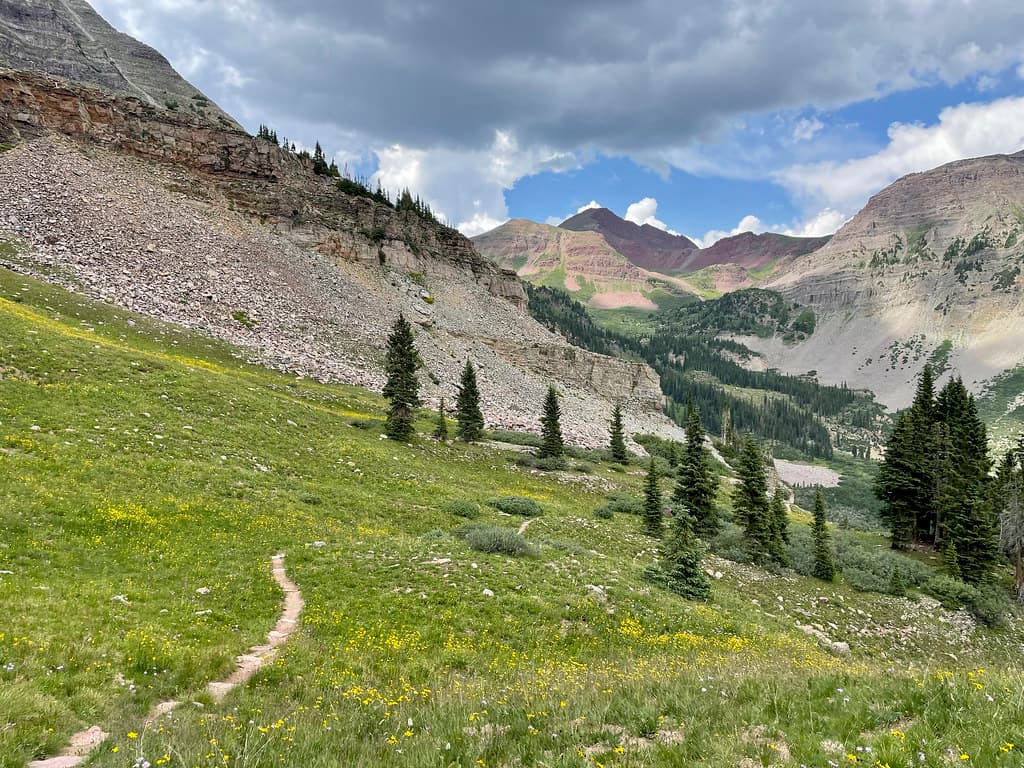 Finally reaching grass at the end of a seemingly never-ending scree slope near the end of our descent of North Maroon, a storm visibly brewing.